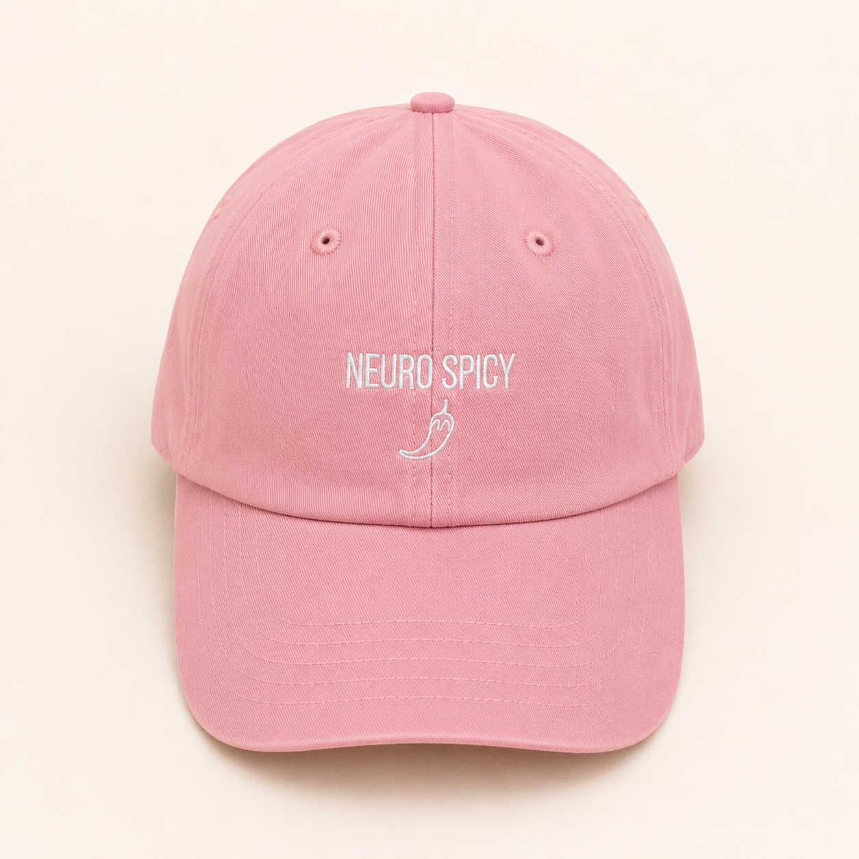 Pink cap with 'NEURO SPICY' text on a beige background