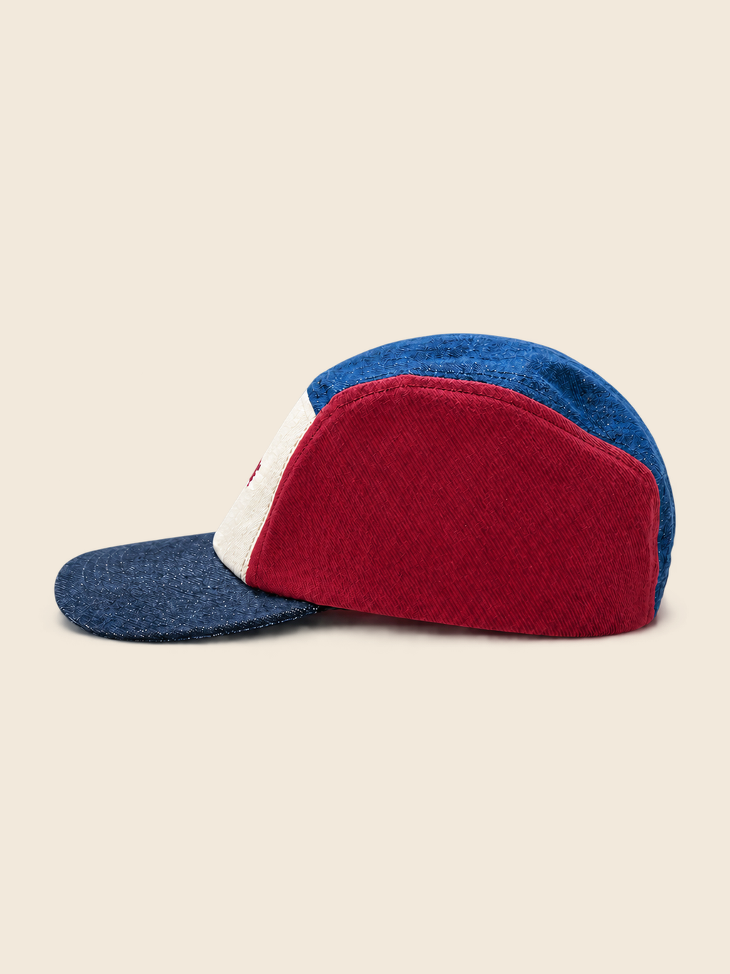 A denim kids camp cap with a colour-blocked design featuring a deep red front panel, a blue back panel, a blue brim, and a white stripe on the side.